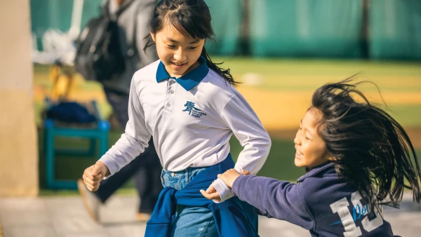 two young female students playing outside the best international school in qingdao