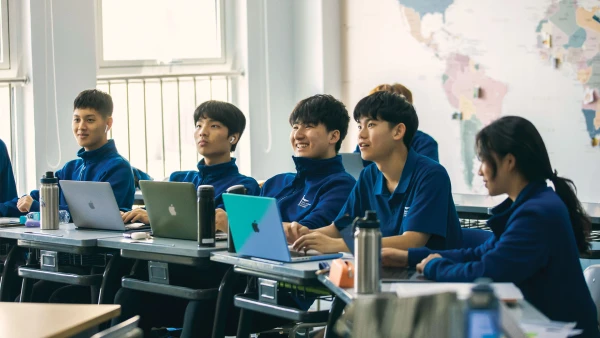 male and female students on their laptops in international school of qingdao education classroom