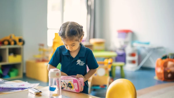 young female student at desk in classroom inside international school of qingdao early childhood learning