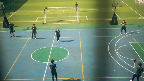 many students playing catch outside international school of qingdao high school learning baseball