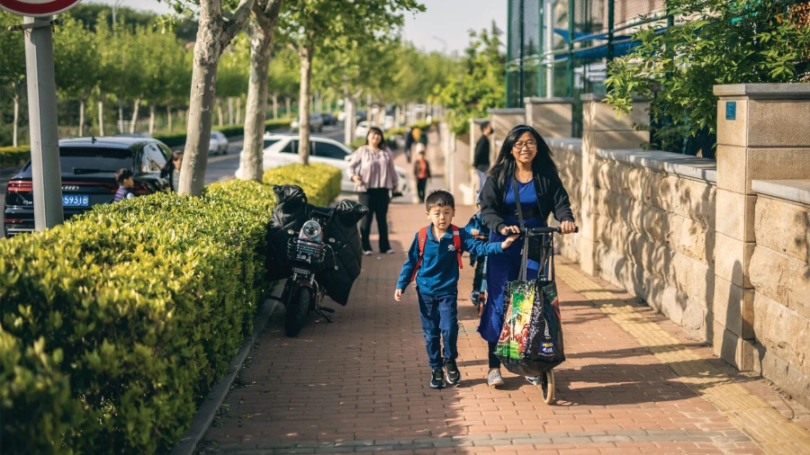 a mother and son walking together to the international school of qingdao