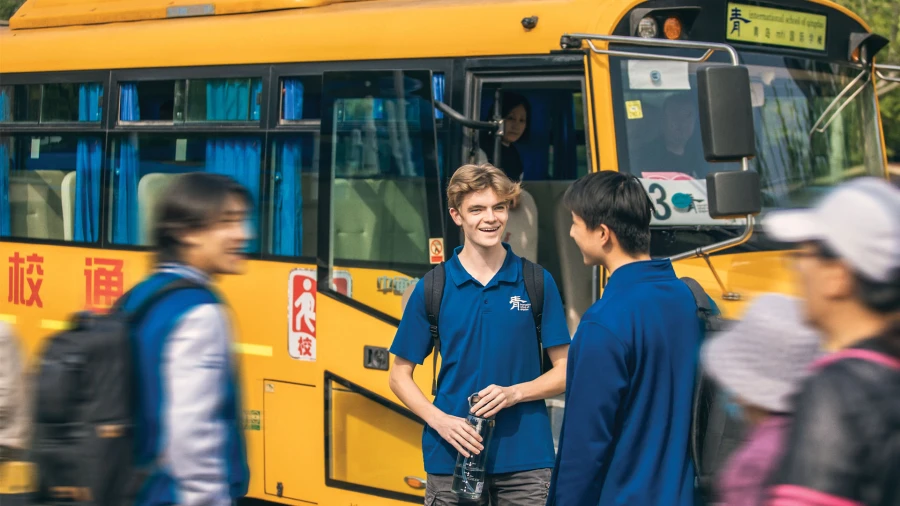 male students waiting for the bus at the best international school in qingdao