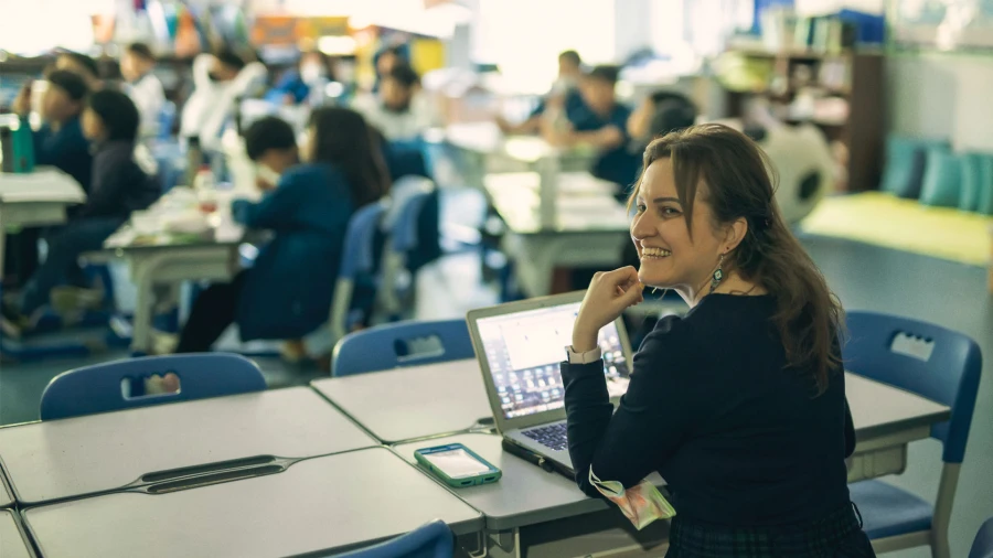 teacher and computer next to students for their international school of qingdao jobs