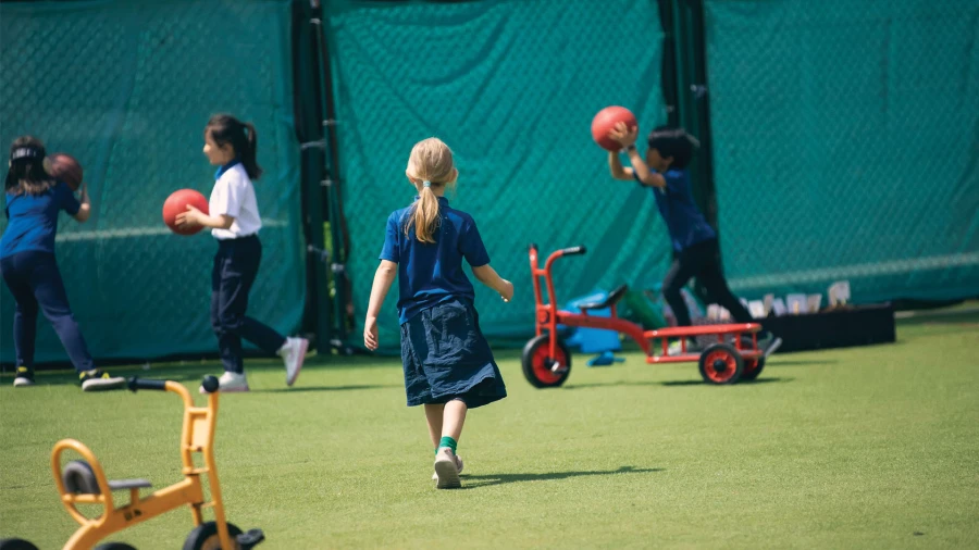 international school of qingdao students playing with balls and bicycles outside